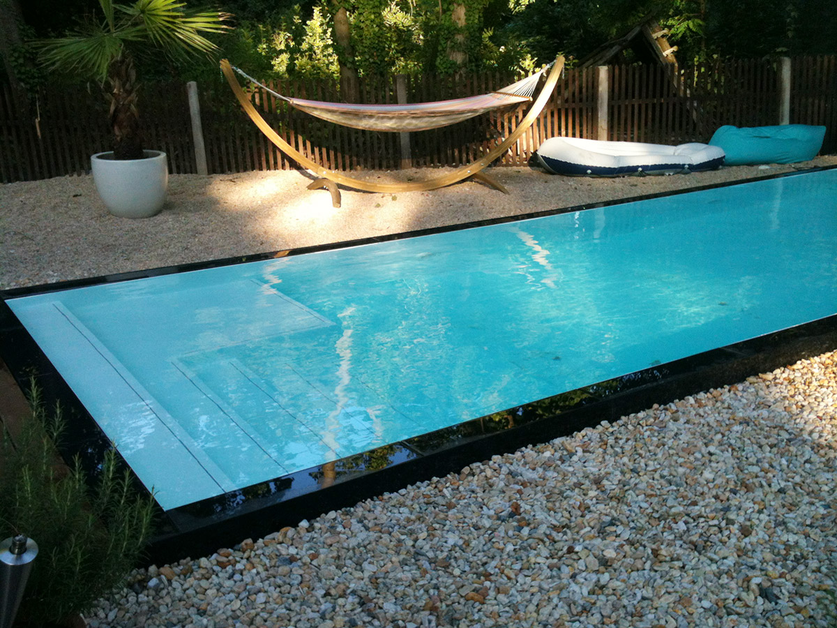 Skimmer swimming pool with pebble deck